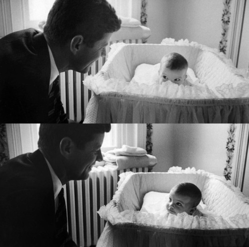 John F. Kennedy admiring his darling baby daughter Caroline as she lies in her crib in nursery at Ge