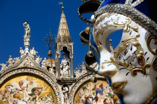 masksandmasquerades:  A Venetian carnival mask with the Basilica of San Marco in Venice, Italy in the background. 