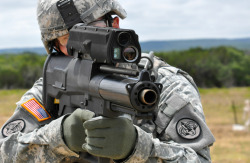 A soldier aims a new XM25 weapon system at Aberdeen Test Center in Maryland. The XM25 is an airburst grenade launcher equipped with a laser rangefinder and programmable grenade that can be set to detonate at a precise distance, for example, directly above