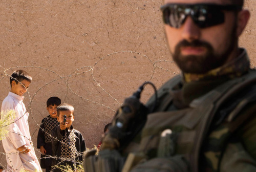 An Italian soldier of NATO’s International Security Assistance Force (ISAF) stands guard as an Afghan boy aims a toy pistol inside Herat’s prison, in western Afghanistan on September 14, 2010. (REUTERS/Raheb Homavandi) 