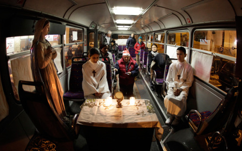 Homeless people attend a Christmas mass celebrated in a bus in Nice, southeastern France on December 25 2010. (REUTERS/Eric Gaillard)