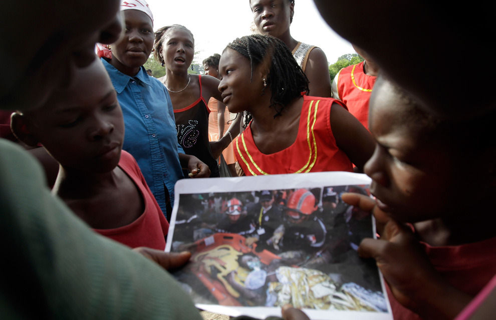 Via: Boston.com The Big Picture
“ Earthquake survivor Darlene Etienne, center, shows a photo of her rescue shot by Associated Press photographer Ramon Espinosa to neighbors in Marchand Dessaline, Haiti, Sunday Jan. 9, 2011. The seventeen-year-old was...