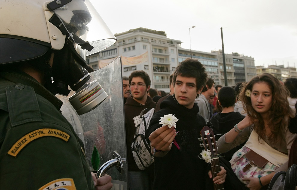 2008 Greek riots - Athens: Young students offer flowers to riot police while others