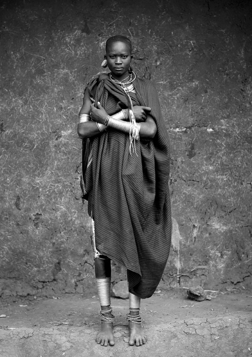 Young Surma woman wearing incredible wrist and ankle jewelry made of wire, braided twin or hair nec