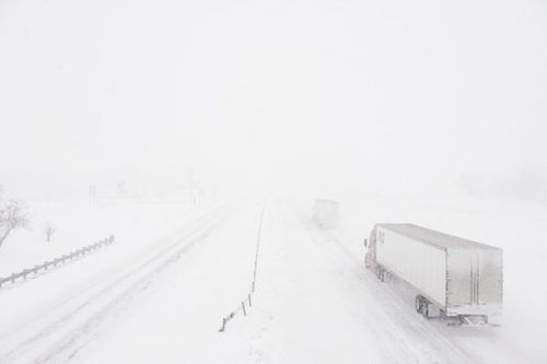Trucks disappear into w hite-out they travel along I-70 near Boonville, Missouri, during a snow stor