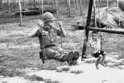 mluce:  A young Vietnamese child and a U.S. soldier of the 25th infantry division test a swingset in a new playground at the American base in Cu Chi, Vietnam. The playground, part of an improvement project, was built by members of the 25th. DATE PHOTOGRAP