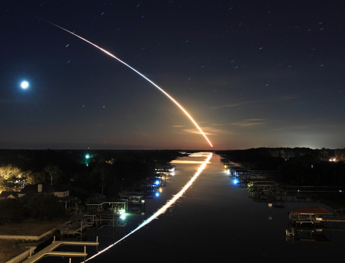 The launching of a shuttle viewed from Florida on February 13, 2010. The Moon and stars create trail