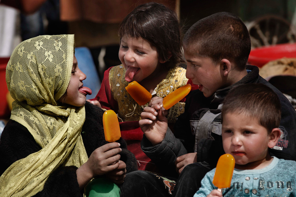 quelowat:  Afghan children play as they eat ice lollies in Kabul on March 21, the