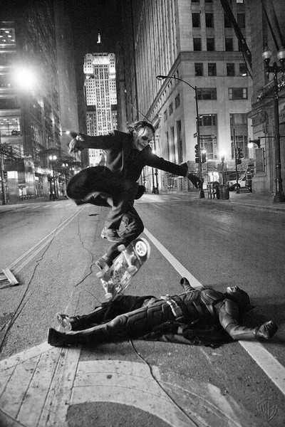 ghost-of-perdition:  Heath Ledger as the Joker skate boarding over Christian Bale as Batman while th