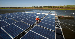 Elvin Batz, an installer at SPG Solar, checks the pontoon structure and panels of a floating solar array in an irrigation pond in Petaluma, Calif. [ ]