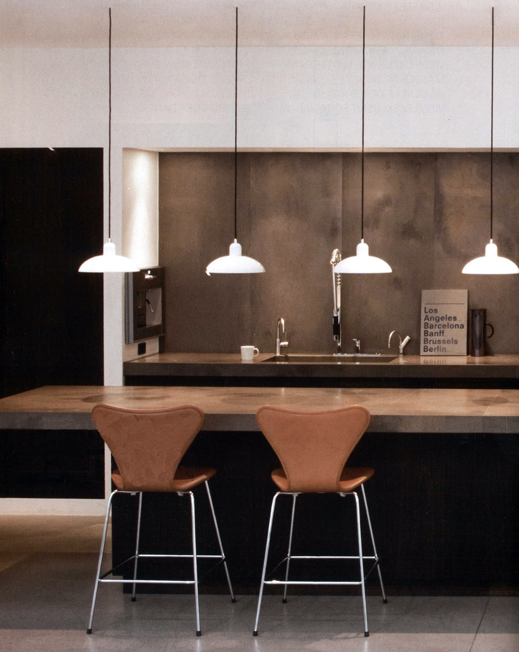 A simple, chic, Scandinavian kitchen all about warmth and contrast. It’s a warm minimalism. It is beautifully designed, even down to the dark cables attached to white pendants. A composition consisting of blocks of color and form. The Series 7 chairs...