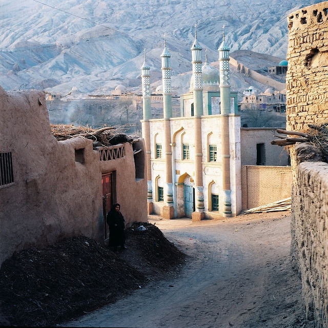 muslimerican:  Woman and mosque in Xinjiang Province, China. [image source] 