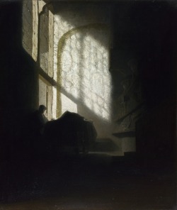   A Man seated reading at a Table in a Lofty