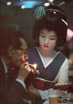 crazy70s: Geisha presents a light to a diner in a Tokyo restaurant, 1969 