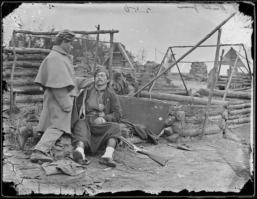 Photograph by Mathew Brady, injured soldier being tended to in an abandoned camp. US Civil War, 1865.