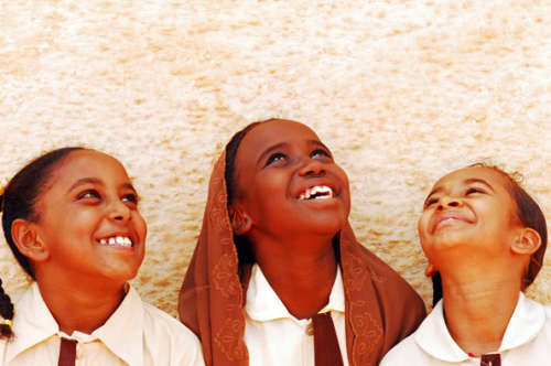 hamyra:  Sudan, Khartoum, cheerful schoolgirls standing together by wall and looking up in front of 