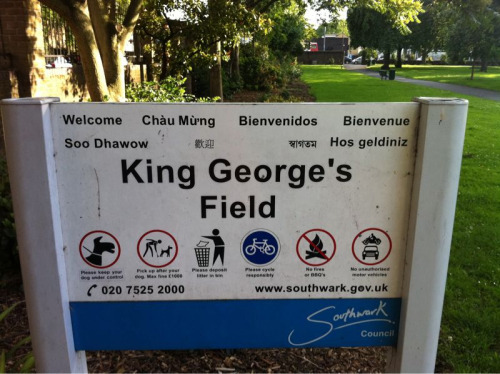 Park sign welcoming residents in common local languages: English, Vietnamese, Spanish, French, Somal