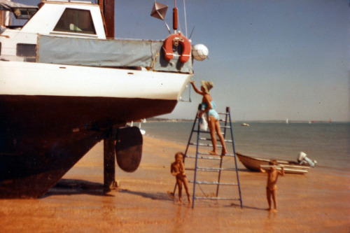 Leonor hard at work painting the yacht, Pampero II, before the tide comes back in and the yacht is a