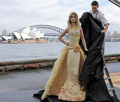 cureempaffu:  pumpumpumkim:  To celebrate Barbie’s 50th birthday, in Sydney, Australia, Mattel  unveiled a nearly seven-foot tall “Barbie doll” chocolate mud cake. The  2,645 lb cake was covered in gold icing, gold silk, and 2,000 Swarovski  crystals