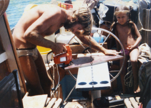 Boat repairs while on the go. Observe the folding table being held up with chain: with three trusty 