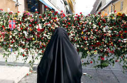 A Muslim woman stands in front of a sea of