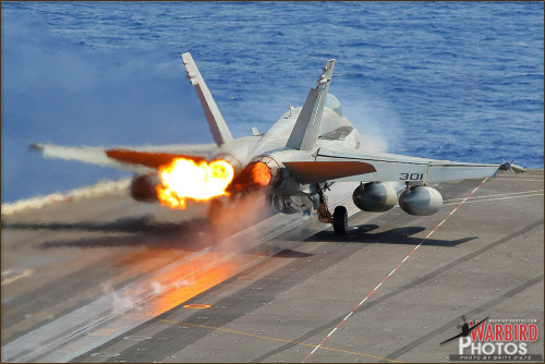 A Boeing F/A-18C Hornet launches from the deck of the USS Abraham Lincoln Aircraft Carrier (CVN-72) 