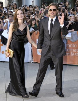 suicideblonde:  Angelina Jolie and Brad Pitt at the Toronto Film Festival premiere of Moneyball today Angelina wearing the Louis Vuitton clutch with the handcuff, very naughty, I love it. 