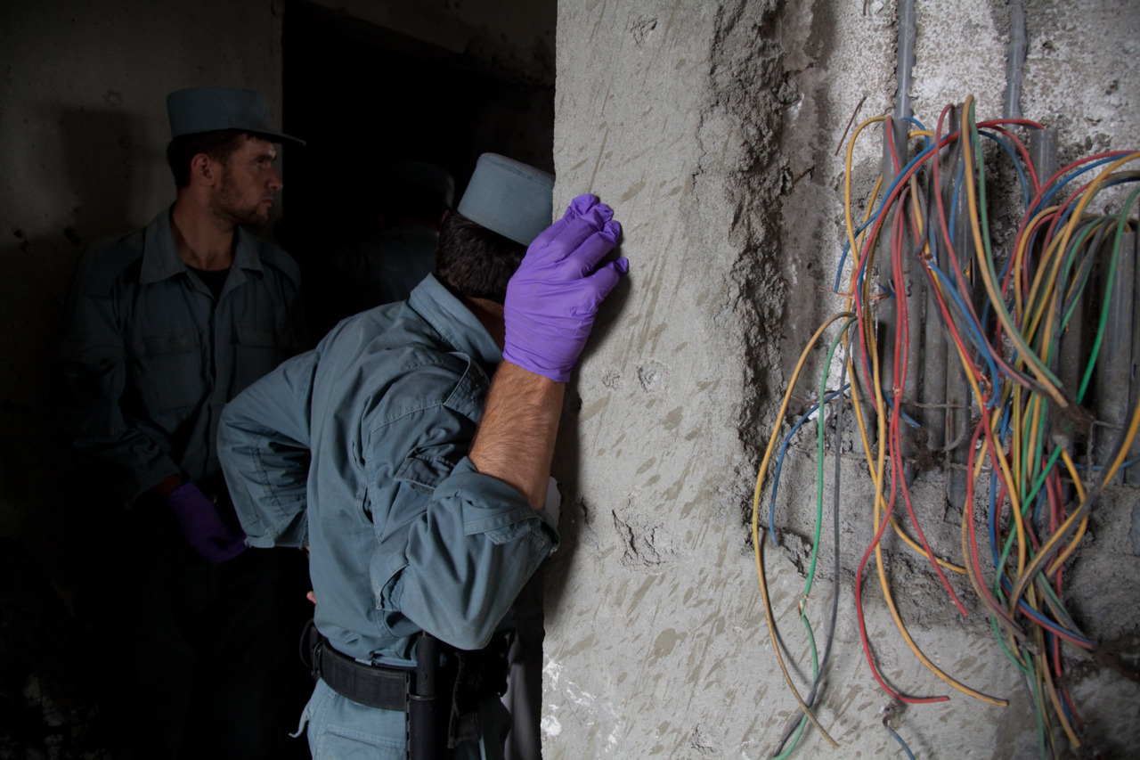 Afghan policemen in latex gloves inspect the bodies of six insurgents killed during a 20-hour attack on Nato’s headquarters and the American embassy in Kabul.