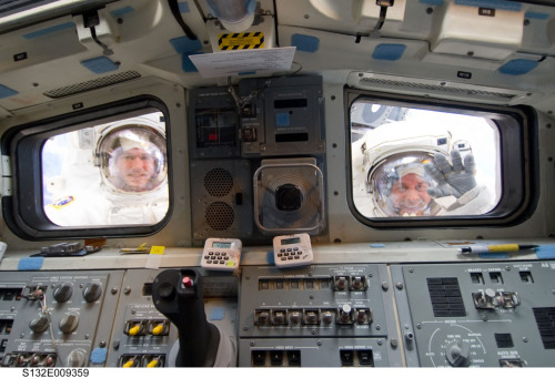 Mike Good and Garrett Reisman as seen through the windows on Space Shuttle Atlantis during EVA, STS-