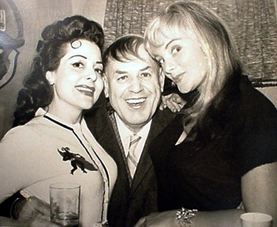 Irma The Body (right) and Rose La Rose (left) sandwich an unidentified man (with