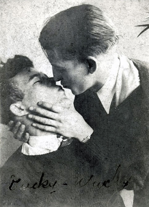 A vintage photograph of two men kissing.