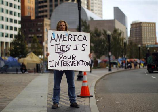 “ A member of the Occupy Boston movement holds a sign outside their encampment in Boston, Massachusetts October 12, 2011. REUTERS/Brian Snyde
”