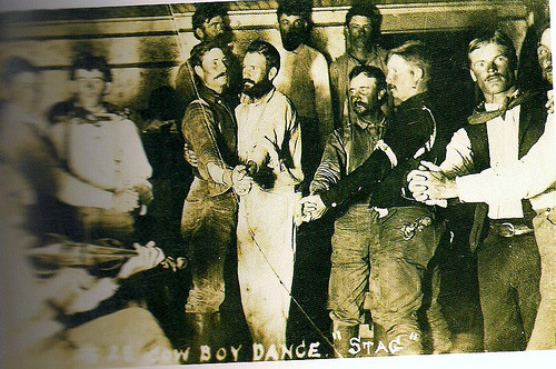 A vintage photo of a group of men dancing together. 