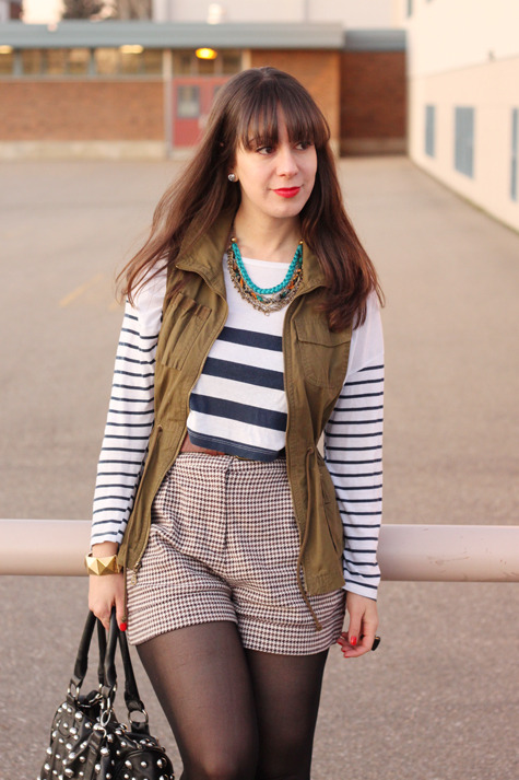 Black tights, brown tartan shorts and white sweater with black stripes