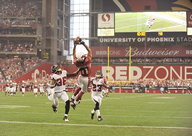 siphotos:  Cardinals receiver Larry Fitzgerald leaps over Lawyer Milloy (36) and