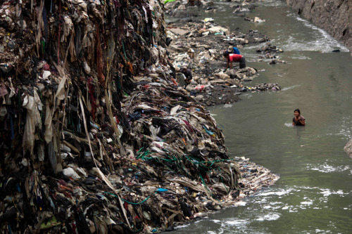 reblololo:  Dangerous work: “The Mine” in Guatemala City - The Big Picture - Boston.com A youth who goes by the name Baluquita (15) searches for scrap metal in contaminated water next to a mountain of garbage. (Rodrigo Abd/Associated Press) 