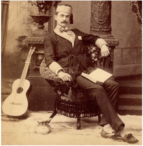 The archetypal Gentleman - posing with fez, guitar, potted plant and the indispensably manly spittoo