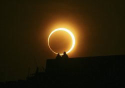 the-star-stuff:  Two men sit on a bridge to watch an annular solar eclipse in Zhengzhou, Henan province, January 15, 2010. The longest, ring-like solar eclipse of the millennium started on Friday, with astronomers saying the Maldives was the best place