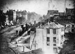 whispercracklelikefiredust:  “Boulevard du Temple”, taken by Louis Daguerre in 1838 in Paris, was the first photograph of a person. The image shows a street, but because of the over ten minute exposure time the moving traffic does not appear. The