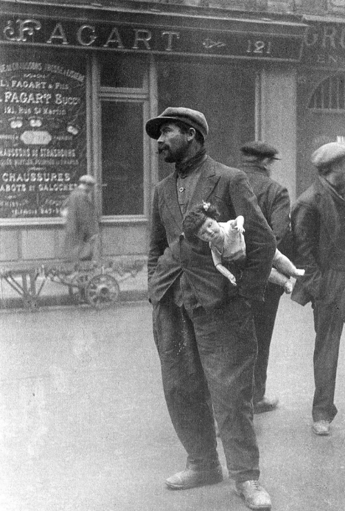 Destitute man standing in street in near Les Halles holding doll under his arm Alfred Eisenstaedt