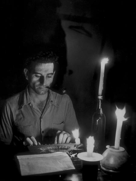 legrandcirque:Carl Mydans, TIME correspondent Melville Jacoby at his typewriter, working by candleli