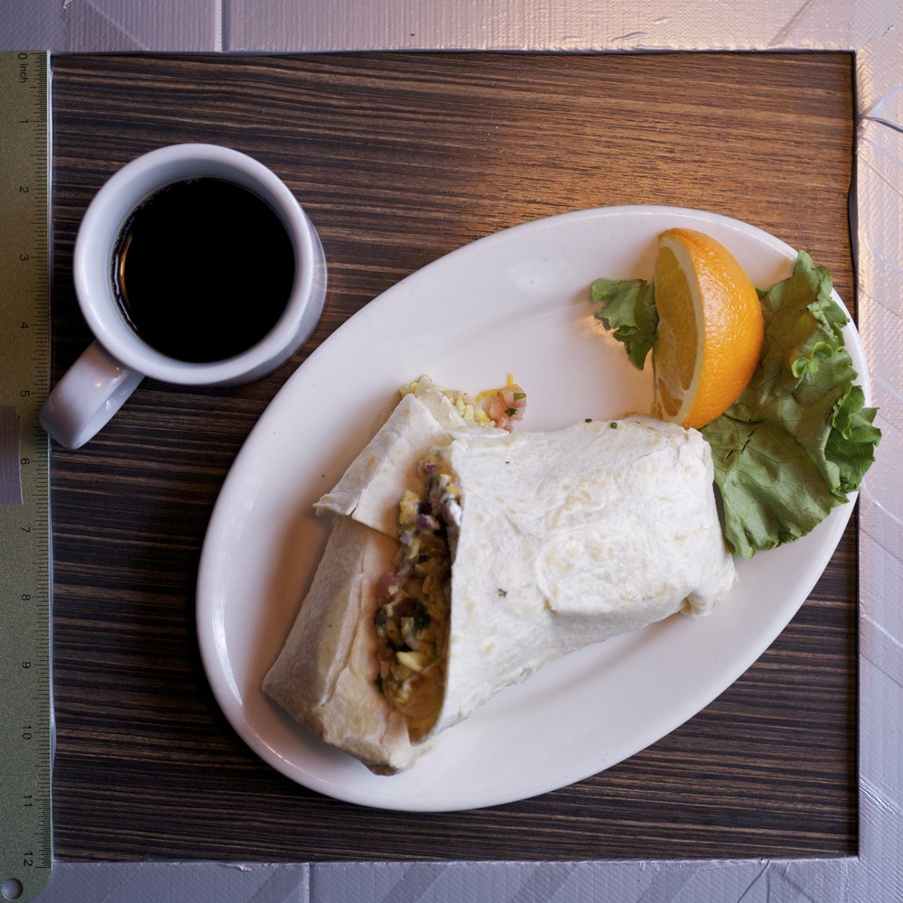 Breakfast burrito with bacon and black beans, orange wedge and lettuce garnish, with black coffee, at Christie’s on N Lombard St.
This is the closest breakfast place to my house by at least a few blocks; I eat breakfast there probably once a week on...