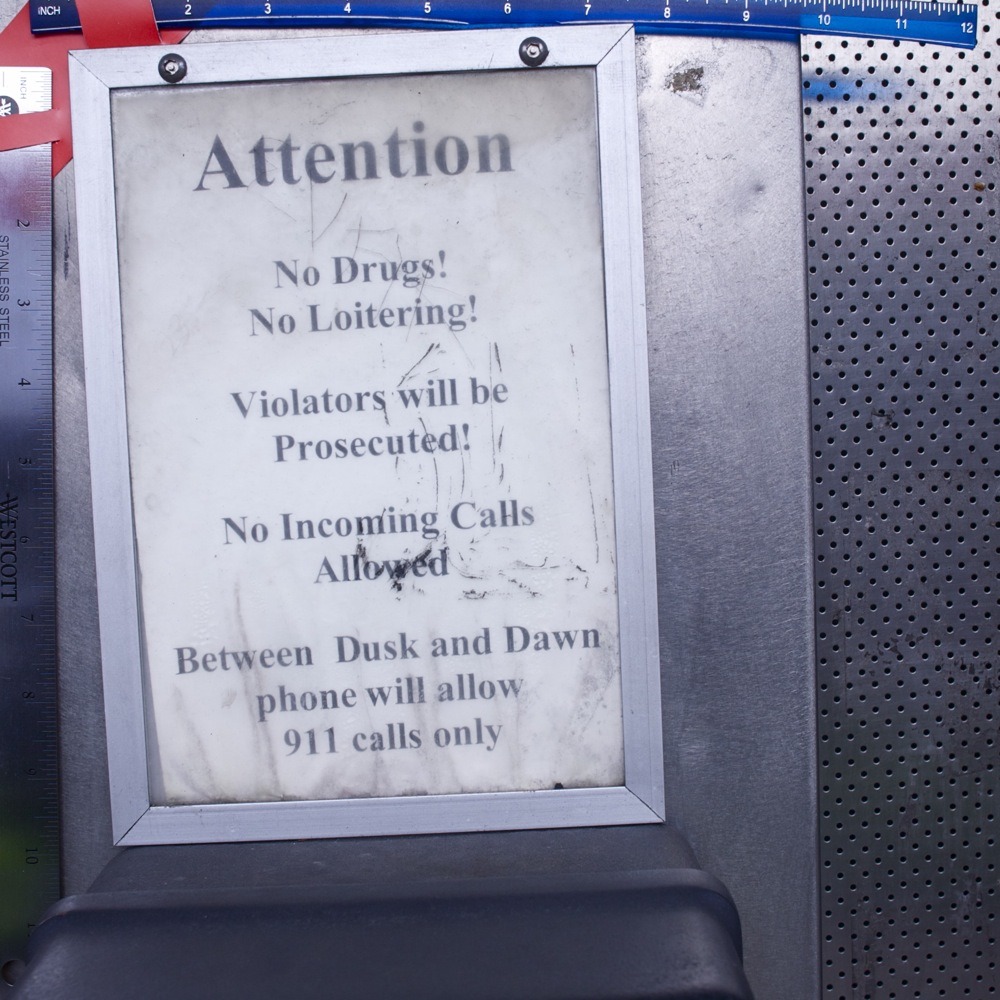 Payphone rules in plastic case with scratched-in graffiti. Lombard transit center bus stop, N Lombard and N Interstate.
“Attention - No Drugs! No Loitering! - Violators will be Prosecuted! - No Incoming Calls Allowed - Between Dusk and Dawn phone...