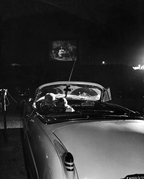 legrandcirque:  A young couple cuddling while watching a movie at a drive-in. Photograph