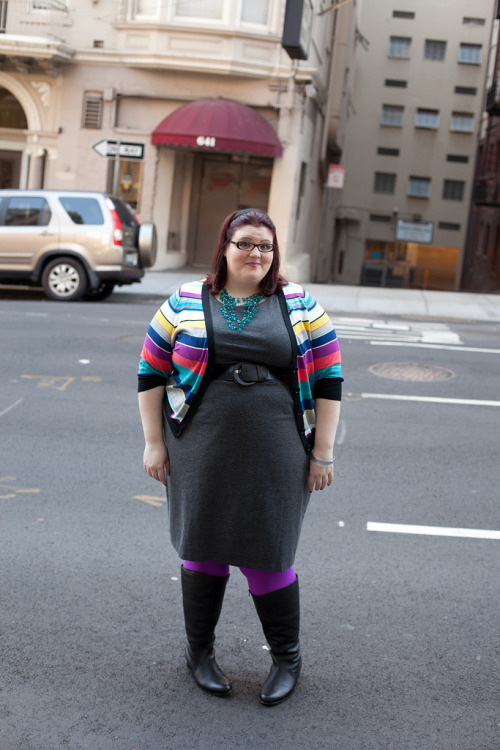 Bright purple tigts with grey dress, black boots and rainbow striped coat