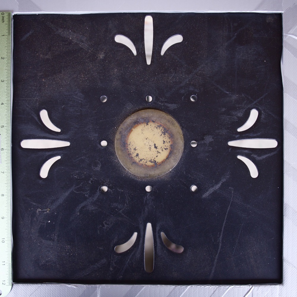 Symmetrical cut out fleur-de-lis type pattern in black metal tabletop, restaurant storefront, N Lombard St.