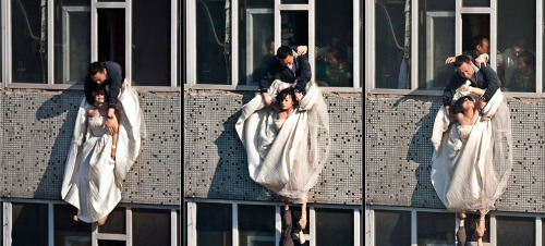 ibeching:  In this combination picture taken in May, a 22-year-old woman in a wedding gown is grabbed by Guo Zhongfan, a local community officer, as she attempts to kill herself by jumping out of a seven-story residential building in Changchun, Jilin