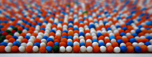  “At a distance of 16 feet, the sprinkles blur, tricking the human eye into believing that it is looking at a large photograph. Only when you closely examine the work do you realize that it has been created entirely with tiny spheres of candy. Taking