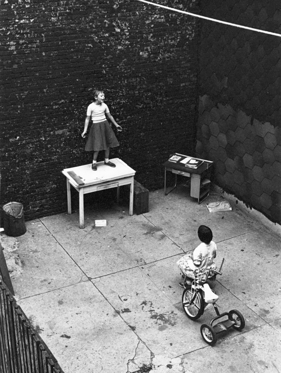 William Gedney
Girl standing on desk in courtyard, performing for a seated girl, 1955
Thanks to wonderfulambiguity