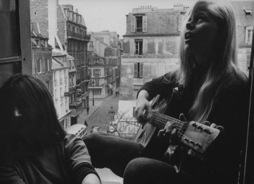 cations:1961: A student playing guitar in Paris. ph: Loomis Dean